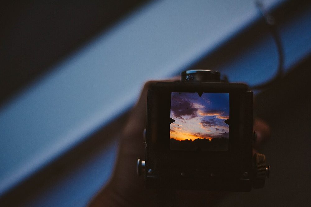A photographer reviewing pictures on the screen of a camera